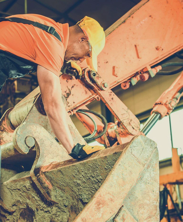 Mężczyzna na&nbsp;łyżce koparki